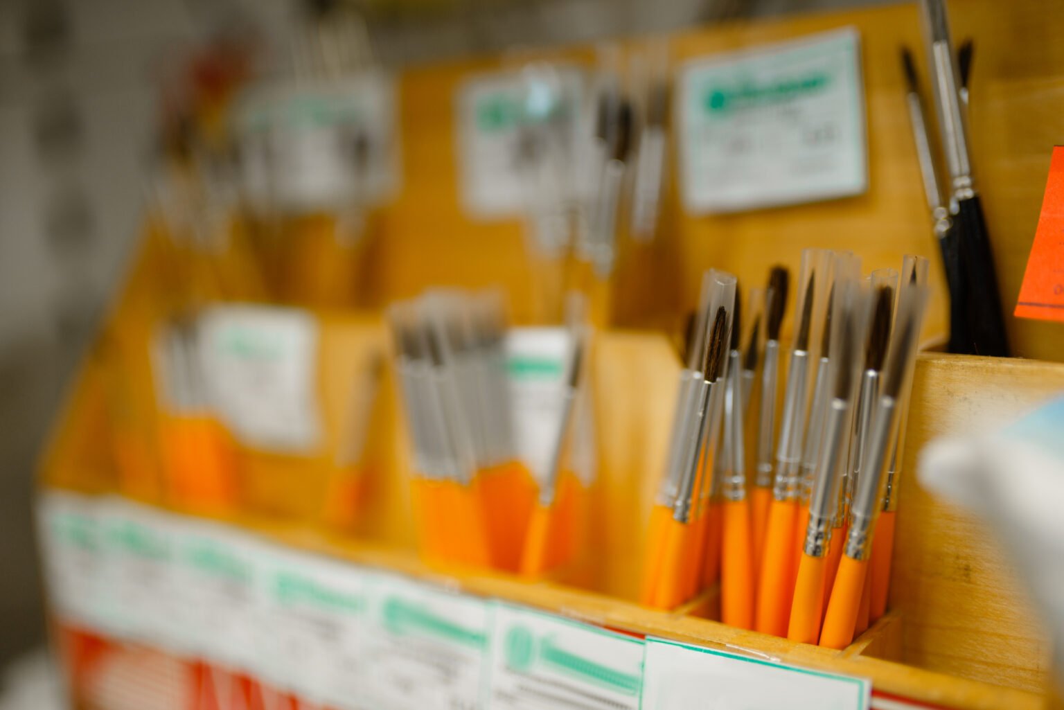 Shelf with paint brushes in stationery store, nobody. Office supplies assortment in shop, rows of accessories for drawing and writing, school equipment
