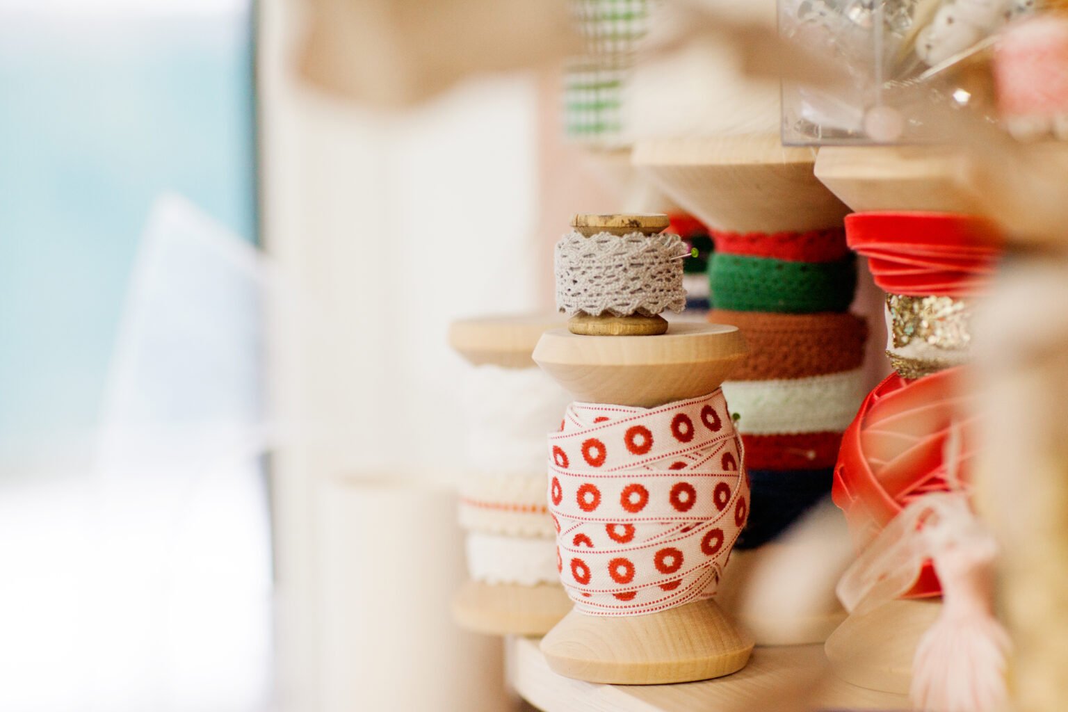 A set of sewing spools with a ribbon is on the desktop. Side view