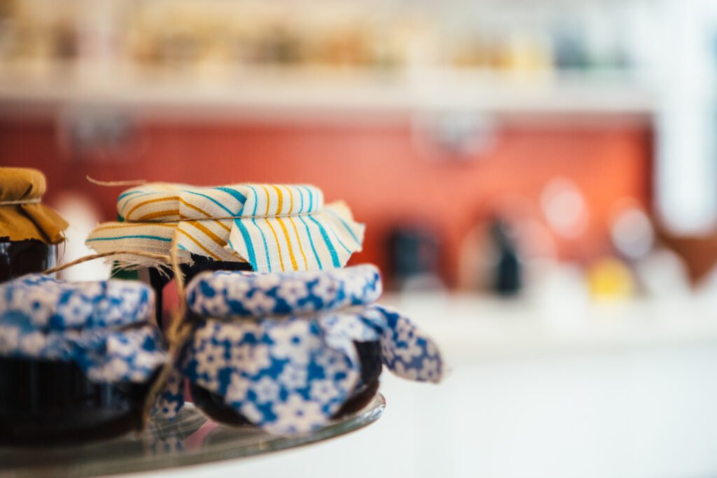 Close up of cakestand with jars of homemade jam. Bokeh
